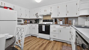 A modern kitchen with white cabinetry, a built-in oven, microwave, and a sink. - Elegant Harvard Free Parking • Prime Location, 2 Bed 1 Bath (Cambridge)