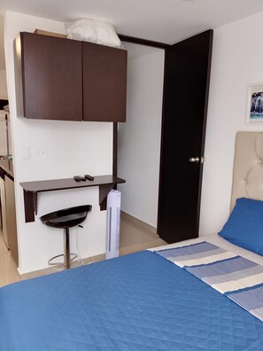 A bedroom with a bed, a desk, a chair, a wardrobe, and a door. - Beautiful and cozy studio apartment. Refugio Perfecto in Medellín (Medellín)