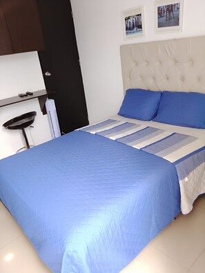 A bedroom with a bed, a nightstand, a lamp, and a door. - Beautiful and cozy studio apartment. Refugio Perfecto in Medellín (Medellín)