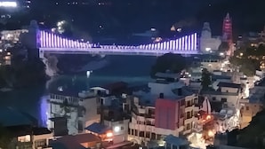 Uma cidade com uma ponte bem iluminada, edifícios e um rio.