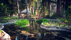 A tranquil garden with a pond, a gazebo, and a wooden bridge. - Wooded Cabin Perfect for South Lake Tahoe Day Trips (El Dorado County)