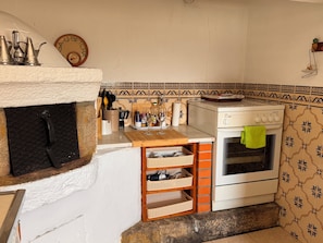 A compact kitchen with a built-in oven, a small countertop, and a decorative backsplash.