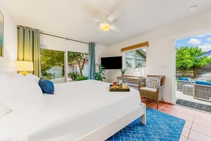 A bedroom with a bed, a desk, a chair, a TV, and a balcony with outdoor furniture. - La Jolla Shores! Beach Across Street+Walk Everywhere (San Diego)
