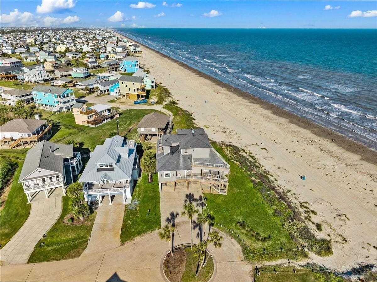 Un quartier résidentiel situé sur la côte, avec des maisons, une plage et une vue sur l’océan.