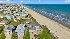 A coastal residential area with houses, a beach, and ocean views. - Beachfront 5BR | Hot Tub & Fire Pit | Game Room (Galveston)
