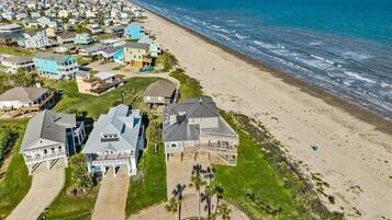 Un quartier résidentiel situé sur la côte, avec des maisons, une plage et une vue sur l’océan.