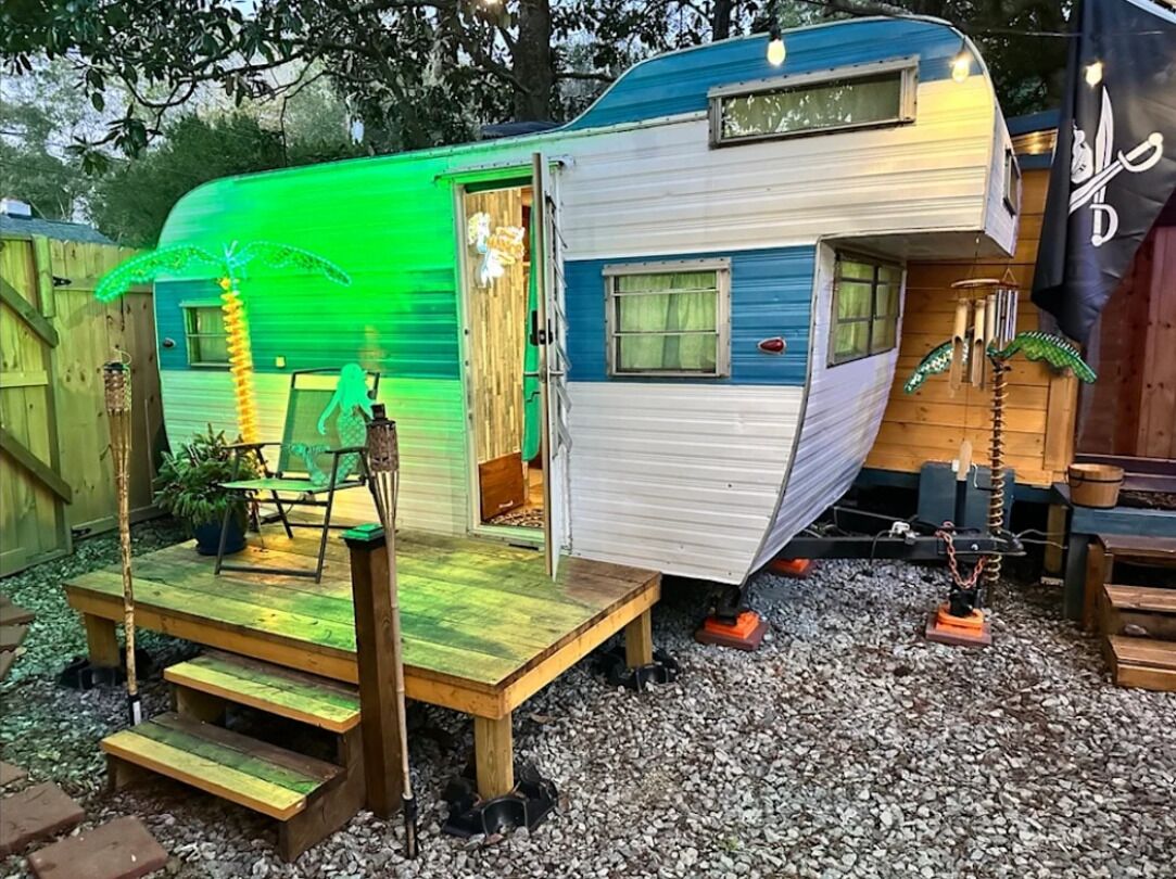 A mobile home with a porch, a small deck, and a window.