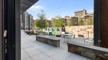 An outdoor patio with seating, a fire pit, and a stone wall.