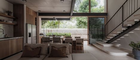 Un interior moderno con cocina, comedor y una escalera.