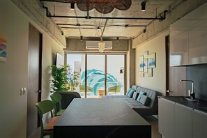 A modern interior with a dining area, sofa, and kitchen. - Pacific Surfside is a bright ocean-view residence in Zonset Surf Residences, El Zonte's Surf City. Featuring two bedrooms, two bathrooms, a private terrace, resort-style amenities, and accommodations for up to five guests. (El Zonte)