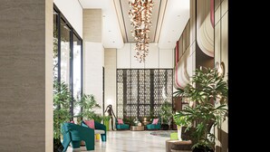 A spacious lobby with seating, a decorative hanging light, and potted plants. - Fave+ Hotel Lampung (Bandar Lampung)