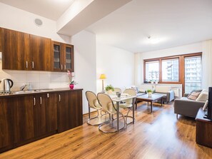 A modern apartment with a kitchen, dining area, and living room.