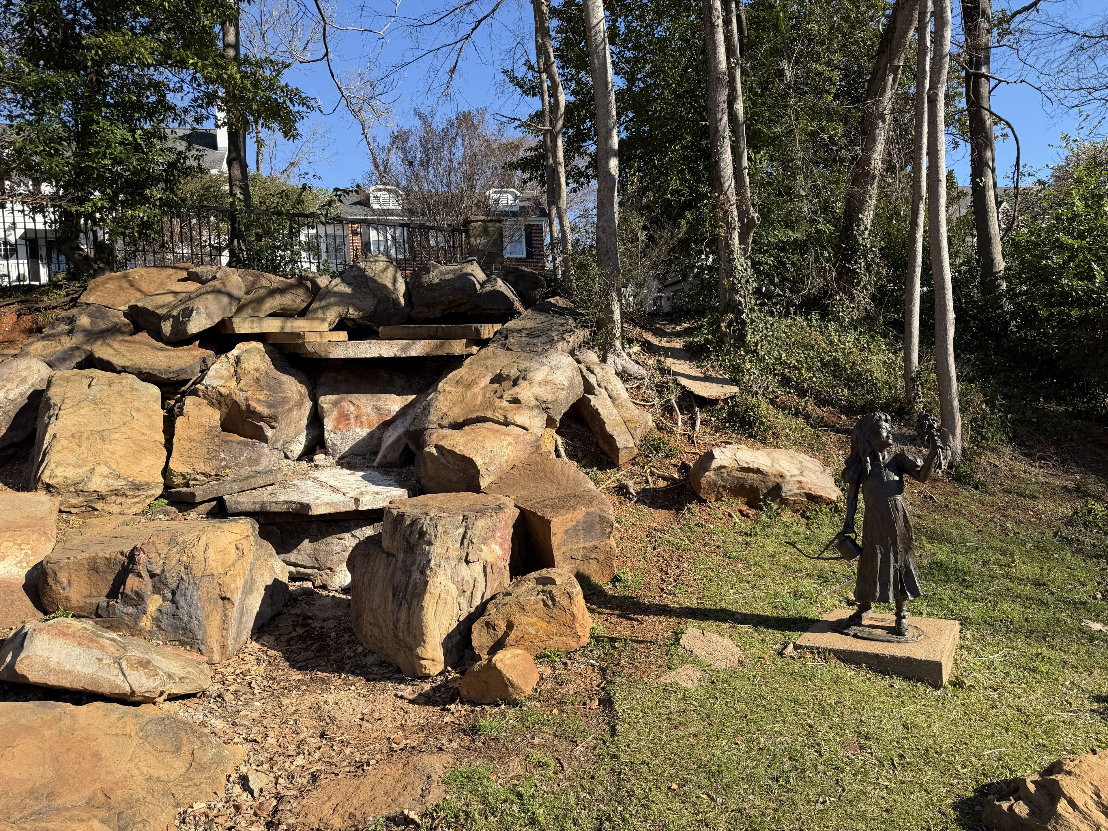 Un espace extérieur rocheux où se trouve une statue d’une femme.