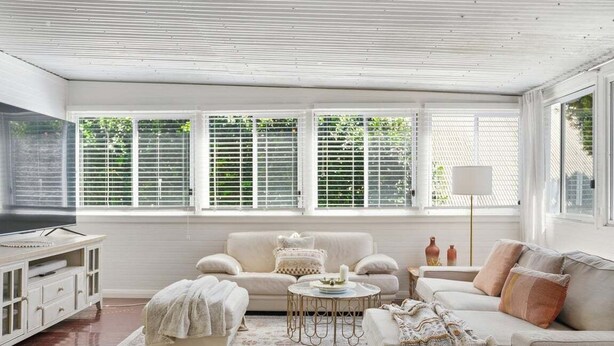A living room with a sofa, armchair, coffee table, and a television. - Pip's Cottage - Pets Friendly, Cafes, Bars, Jetty Beach (Coffs Harbour)