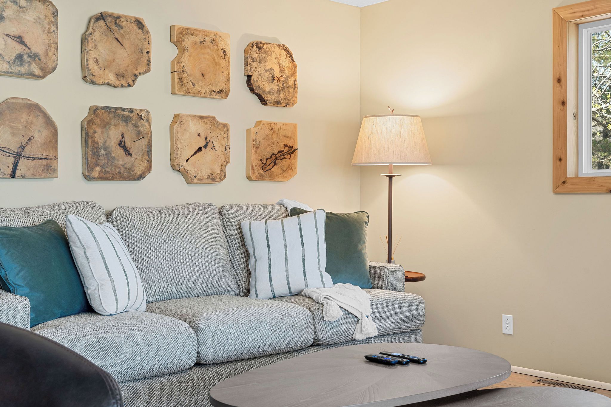 A living room with a sofa, pillows, a lamp, and a coffee table.