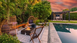 A patio with a fire pit, seating, and a pool. - Villa II Palazzo by Glam Homes (North Miami)