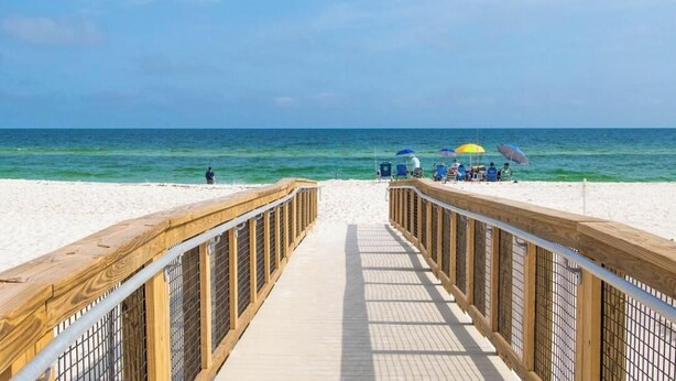 A wooden boardwalk leading to a beach with clear skies and calm sea. - Perdido Bayside Retreat Near Beach! Pool, Dock, Pickleball (Pensacola)