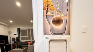 Ein modernes Wohnzimmer mit Wasserspender, einer Wanddekoration und Holzboden.