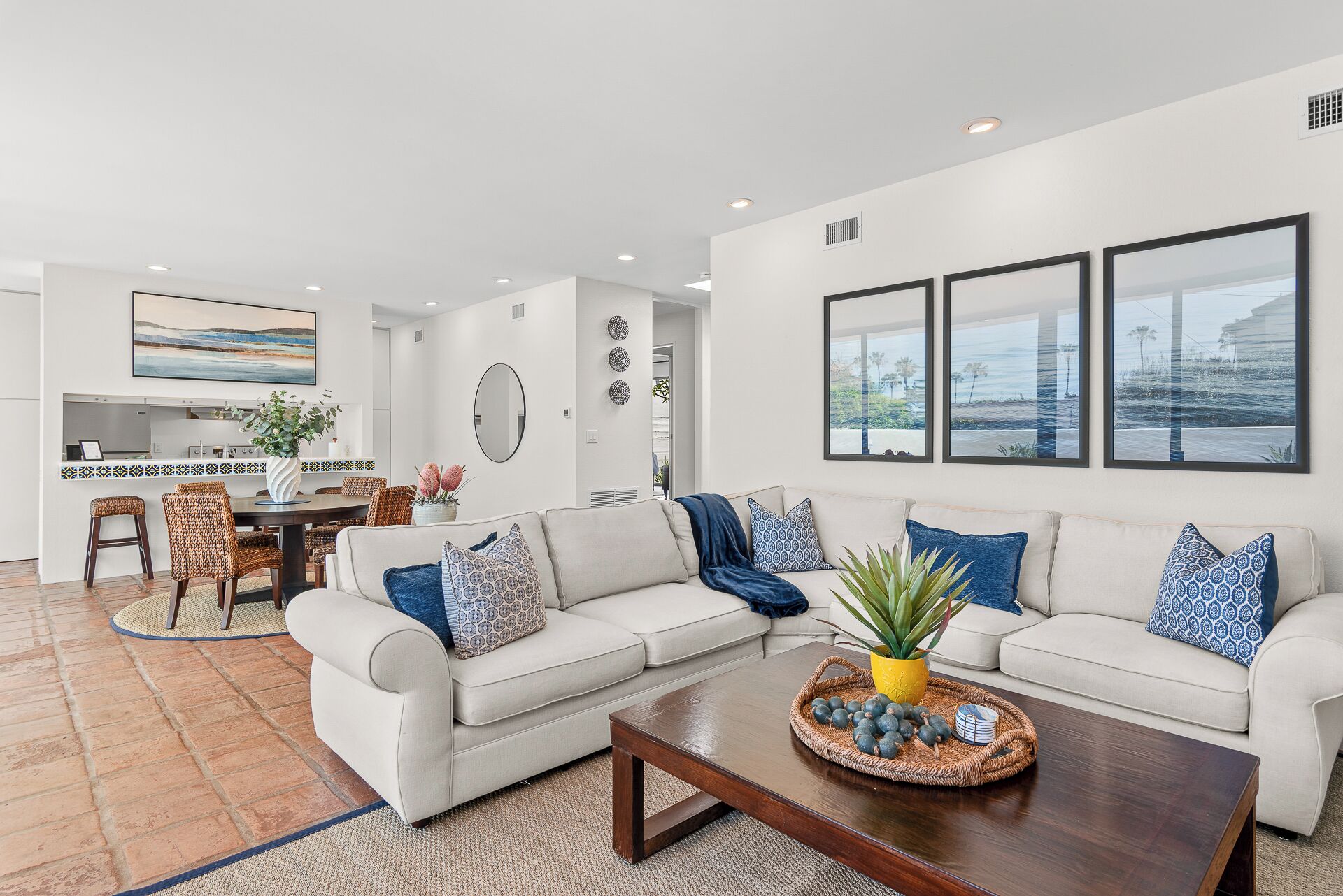 A modern living room with a sofa, coffee table, and dining area.