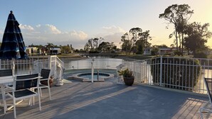 Ein Poolbereich mit Whirlpool, Liegestühlen und Blick auf die umliegende Landschaft.