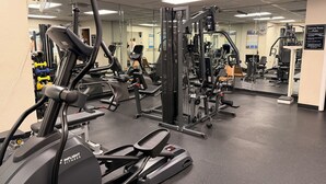 Ein Fitnessstudio mit unterschiedlichen Trainingsgeräten, darunter Laufbänder und Kraftgeräte.