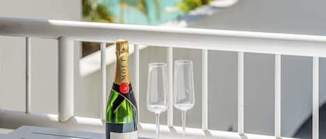 A bottle of Moët & Chandon champagne and two glasses on a white balcony railing.