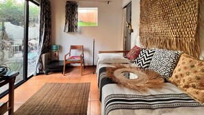 A room with a bed, a chair, a woven wall hanging, and a view through a glass door. - Casa Tacuba country house near the mountain and lake Chapala (San Juan Cosalá)
