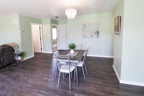 A dining area with a table and chairs, a chandelier, and artwork on the walls.
