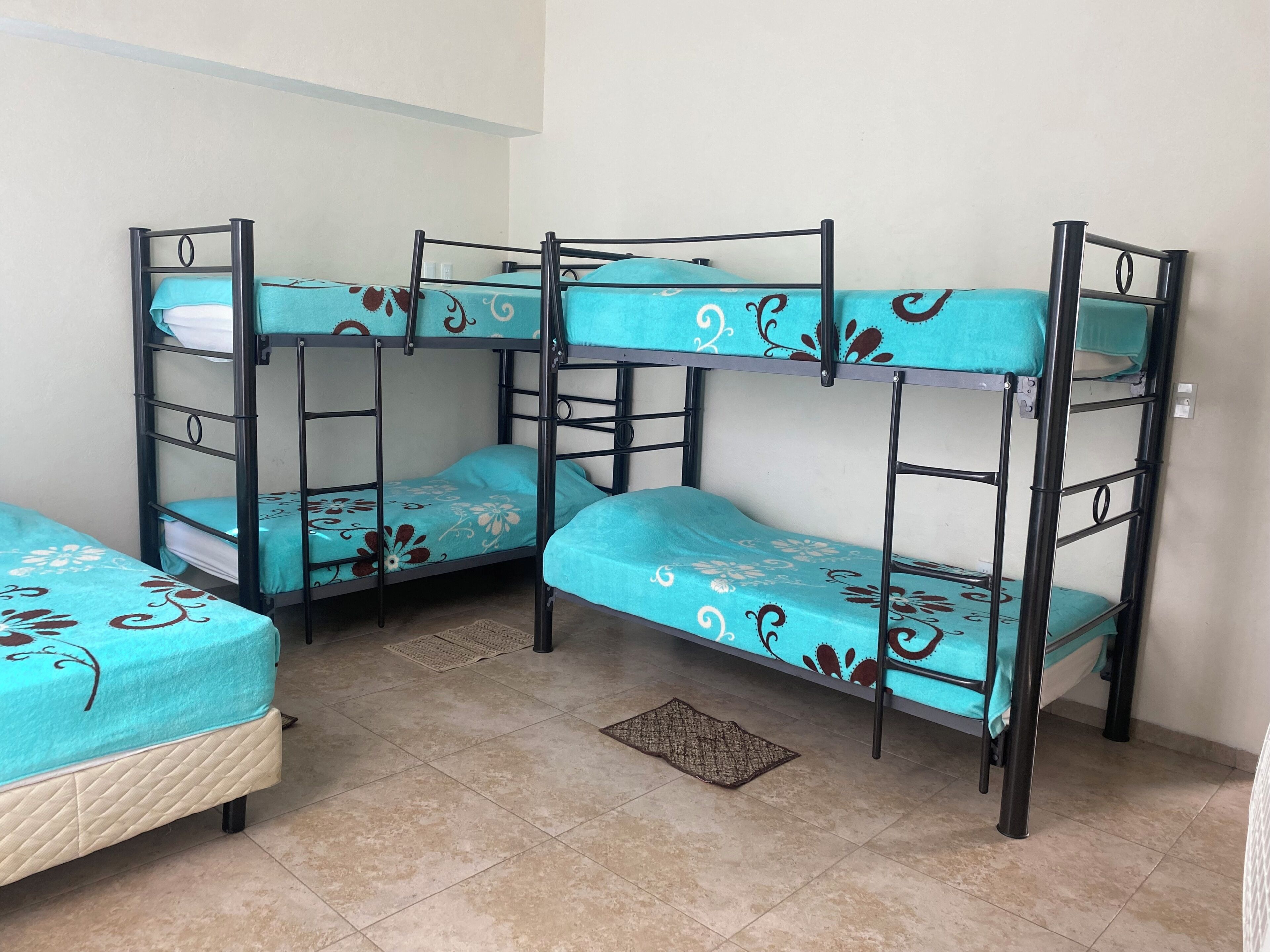 A bunk bed room with a tiled floor and a small rug.