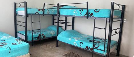 A bunk bed room with a tiled floor and a small rug.