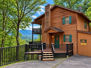 A wooden cabin with a balcony, a porch, and a view of mountains. - Mountain Ridge-VIEWS-Pigeon Forge | Hot Tub, Decks & Fireplace | Sleeps 4 (Pigeon Forge)