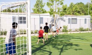 A sports field with a goalpost, surrounded by buildings and trees. - Mobile home with air conditioning and veranda (Cesenatico)