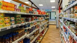 Een gangpad in een supermarkt met diverse verpakte producten en een vriesvak op de achtergrond.