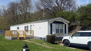 A mobile home with a deck, a fire hydrant, and a parked SUV. - 2 Bedroom, 2 Bath, Mobile Home, Great Location in Athens, Steps To Bike Path (Athens)