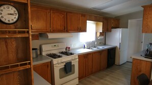 A kitchen with wooden cabinets, a stove, a sink, and a clock. - 2 Bedroom, 2 Bath, Mobile Home, Great Location in Athens, Steps To Bike Path (Athens)