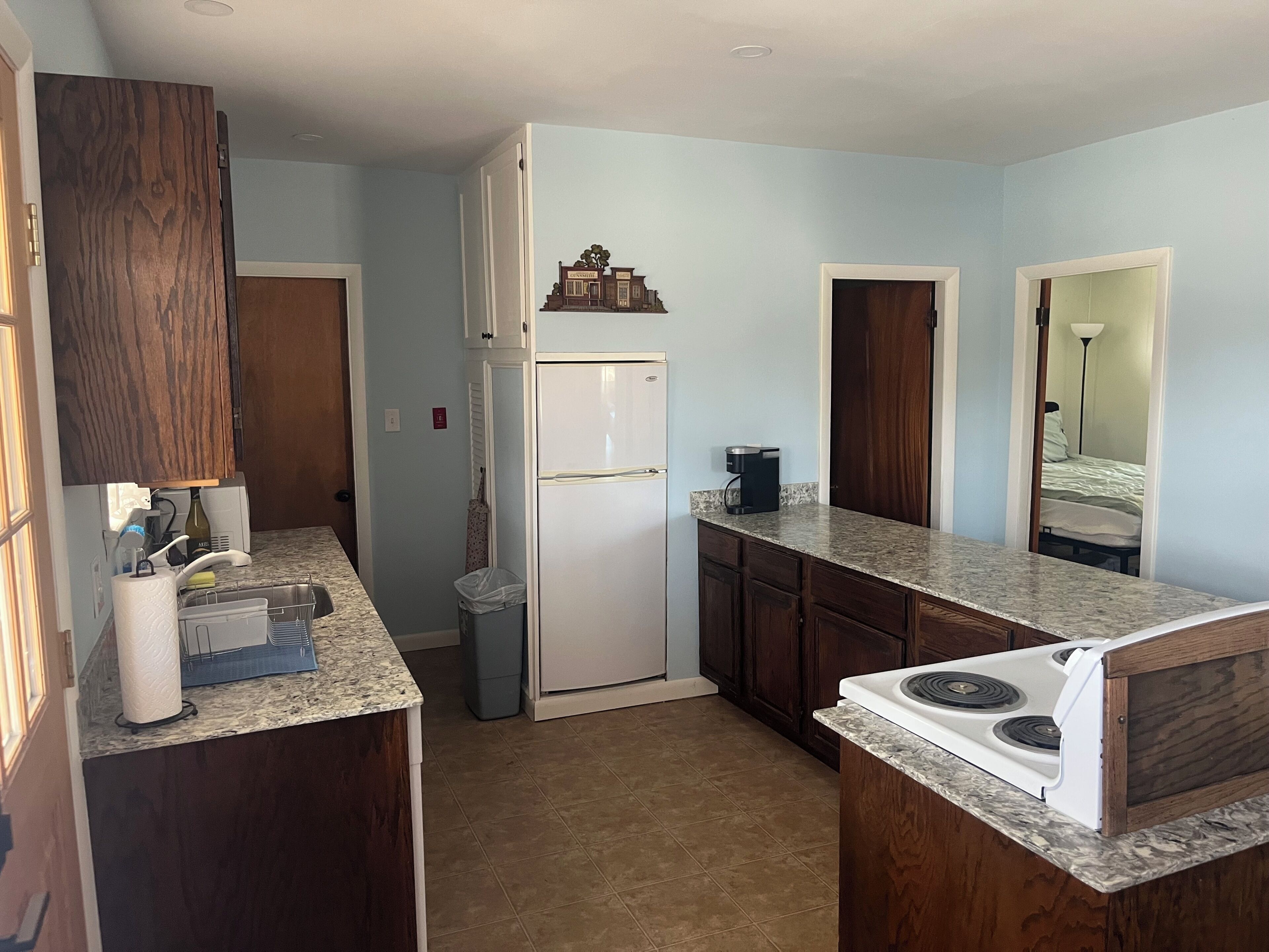 A compact kitchen with a refrigerator, stove, and countertop.