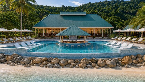 A pool with lounge chairs and a gazebo, surrounded by rocks and palm trees. - Koro Island Resorts Fiji (Koro Island)
