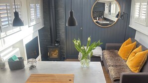 A modern kitchen with a central island, dark cabinetry, and a round mirror above the sink. - Unique 2 Bed Waterside Retreat, Pet Friendly (Worcester)