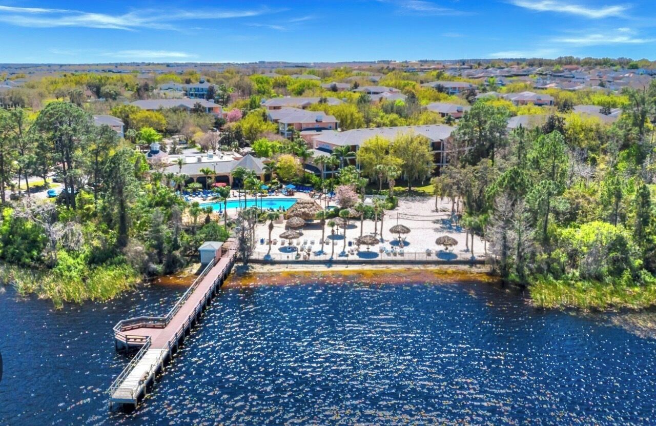 A resort with a swimming pool, a dock, and a view of the surrounding neighborhood.