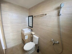 A bathroom with a toilet, sink, mirror, and shower. - Allende Canggu (Canggu)