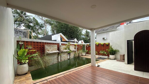 A modern outdoor space with a wooden deck, a small pool, and potted plants. - D'Jiwa by Semesta Management (Turi)