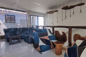 Uma sala de estar moderna com um sofá seccional, uma mesa de centro e um detalhe em madeira.