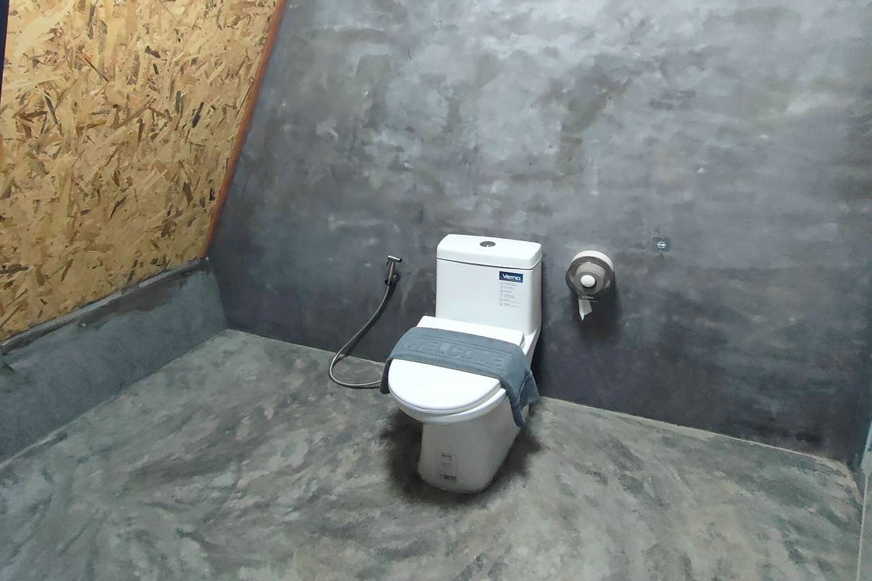 A toilet with a water tank, a flush handle, and a pipe.