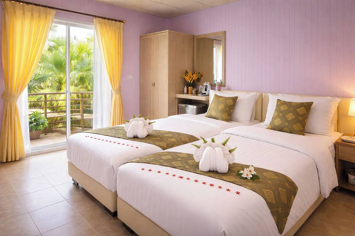 Habitación de hotel con dos camas, un armario, un escritorio con espejo y vistas a zonas verdes.
