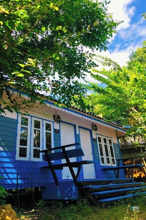 A house with a blue exterior, white windows, and a porch with benches. - Phetmanee Resort (Ko Yao)