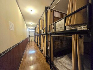 A corridor with bunk beds, wooden flooring, and a sign on the wall. - Nearthepark Backpack Hostel Night Bazaar (Chiang Mai)