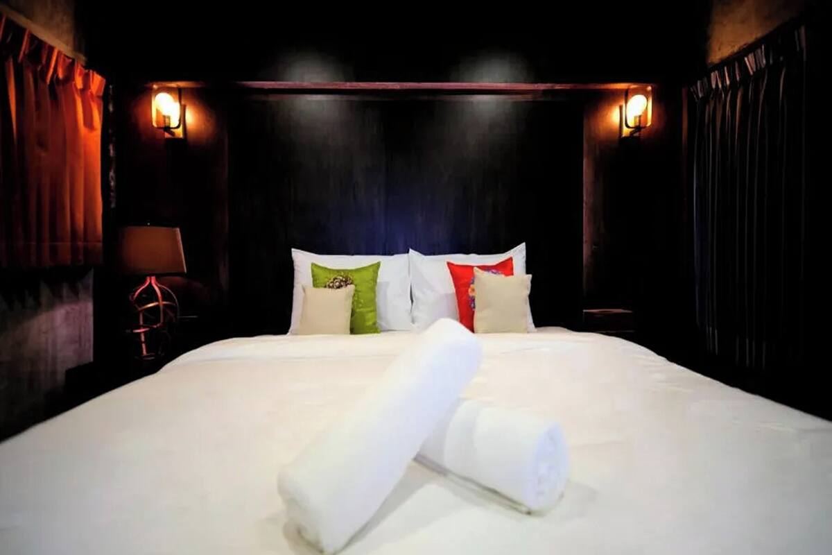 Ein Hotelzimmer mit einem großen Bett, einem Kopfteil und zwei Wandleuchten.