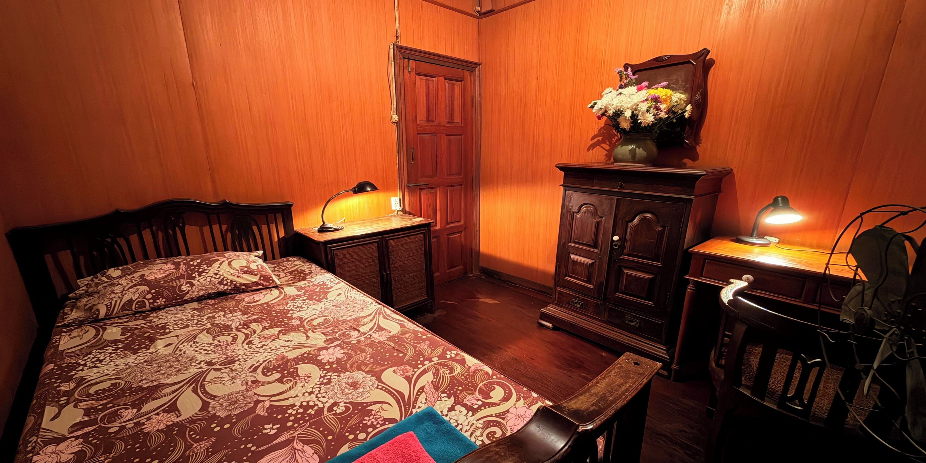 A room with a bed, a desk, a cabinet, and a chair.
