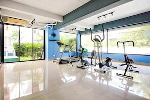 A gym with exercise equipment, large windows, and a clean, modern design.