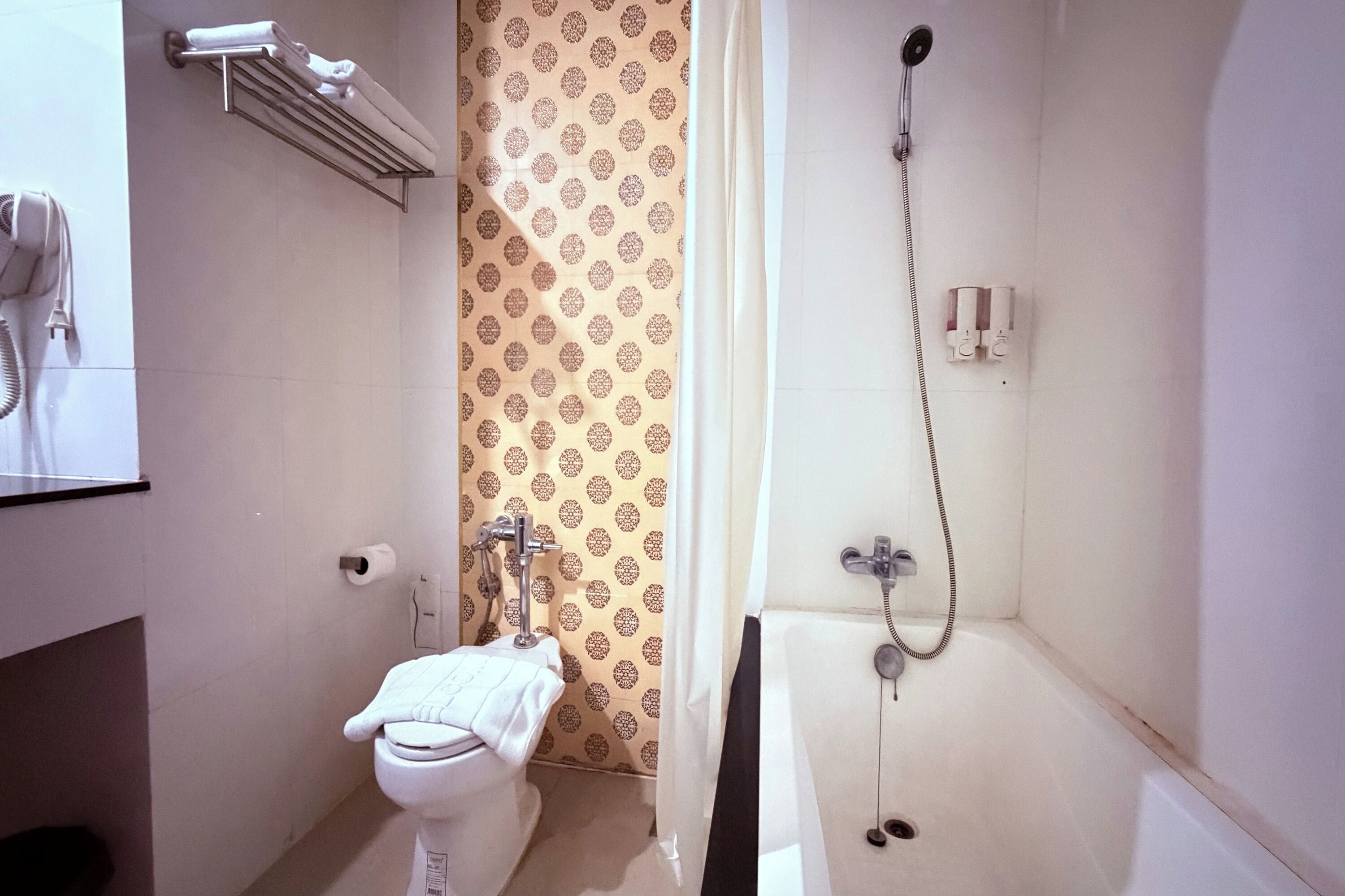 A bathroom with a toilet, a shower, and a towel rack.
